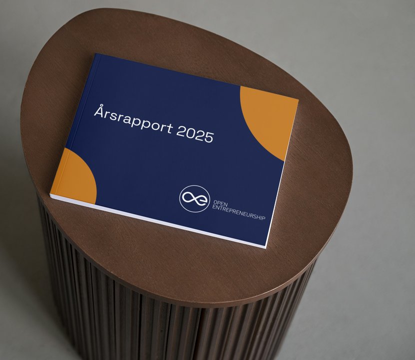 Årsrapport 2025 for Open Entrepreneurship på et rundt træbord